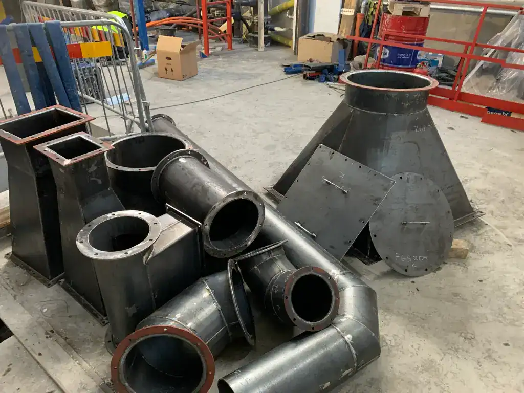 Various metal industrial components on a workshop floor.